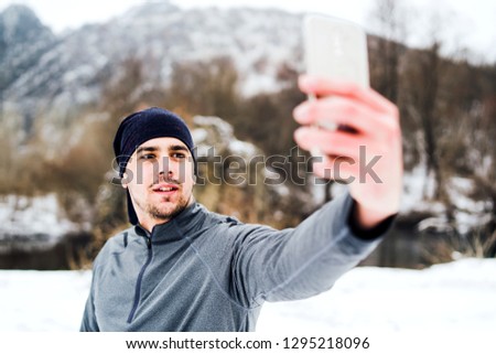 Young Male Athlete Taking Selfie In Winter Outdoor Run Training in Nature