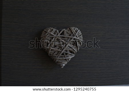 Grey wicker heart on wooden background.Valentine's day concept . Copy space. Card.