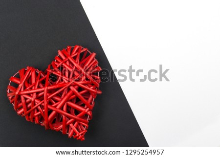 Valentine's day. A red heart woven from a vine on black paper. V
