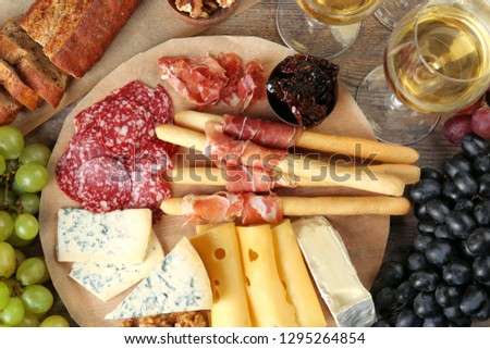 Flat lay composition with wine and snacks on wooden background