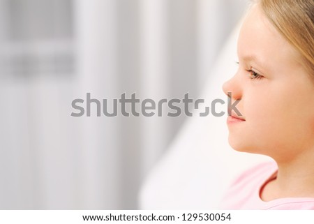 Profile portrait of little girl with long health beautiful hair