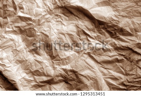Crumpled sheet of paper in brown color. Abstract background and texture for design.