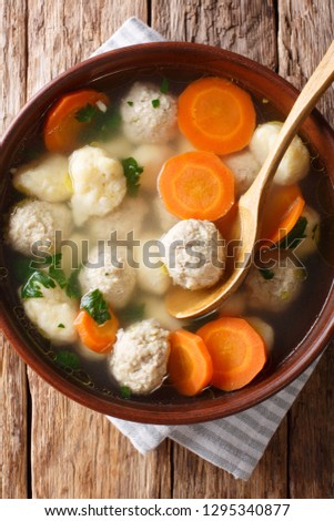 Delicious Danish soup with meat balls, dumplings and vegetables close-up in a bowl. Vertical top view above
