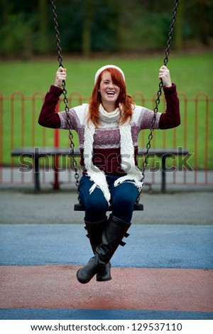 Pretty young red haired female on swing