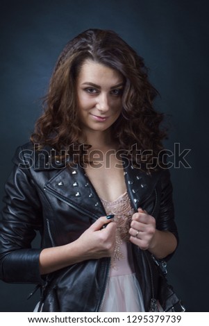 beautiful girl in a ball gown. leather jacket. photo in the studio. great sharpness. large face.
