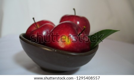 Red apple with stem leaf on bowl. Image fruit