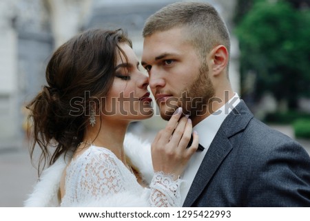 the groom in a gray suit and the bride in a gray dress look at each other, closeup portrait
