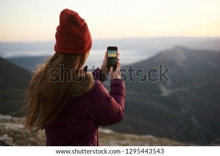 tourist woman taking a mobile shot of mountains by smart phone. Nature mobile photography concept.