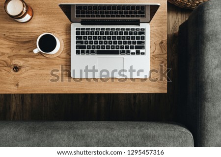 Laptop, coffee cup on wooden table. Flat lay, top view blogger / freelancer workspace minimal concept.