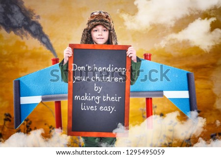 Ambitious charming little boy holding black chalkboard with creative motivational supportive quote, Advice for parents, Standing against colorful background