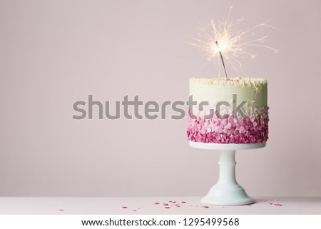 Birthday cake with pink sprinkles and sparkler