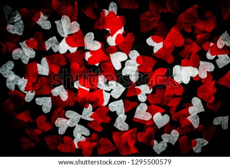 white and red hearts cut from paper on a black background