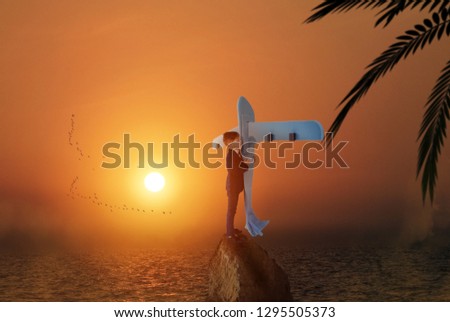 Creative image of cute little boy holding big blue airplane and standing on a rock in the middle of the sea, Beautiful sunset in the background, Travel and imagination concept