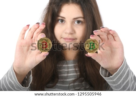Pretty Girl holding new golden cryptocurrency bitcoin in hands on white background. Concept of bitcoin grows and falls in price