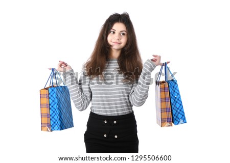 Beautiful girl standing on a white background with a package in the hands smiles a lovely smile