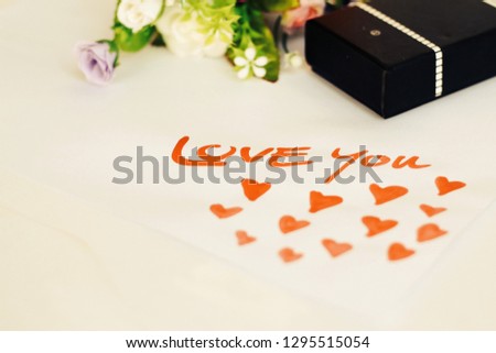 White paper with the message "Love you" red and white background gift box Concept of love day