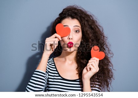 Close up picture photo portrait of nice glad cute sweet optimistic lovely delightful funky glamorous sweet lady hiding face behind small little two hearts isolated grey background