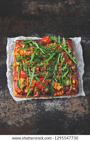 Homemade vegetable vegan pizza with fresh arugula. Top view. Copy space.