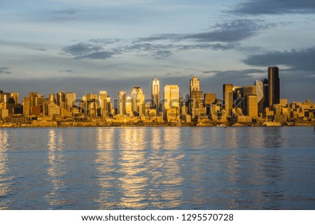 The setting sun is reflected from the skyscrapers in the Seattle skyline.