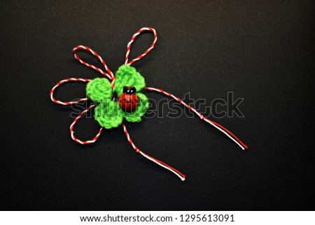Handmade crocheted four-leaf clover with ladybug  and red and white string, known as Martisor, it is a Romanian traditional symbol of the beginning of spring.
