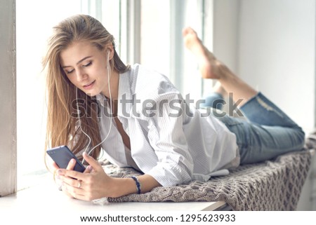 young beautiful woman listens to music through headphones on her phone. digital detox concept