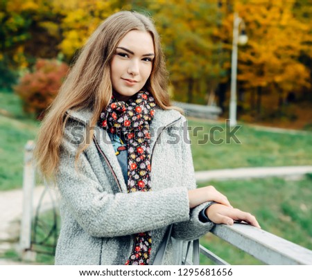 Girl in a gray coat, walking in the Park. The bright long hair.