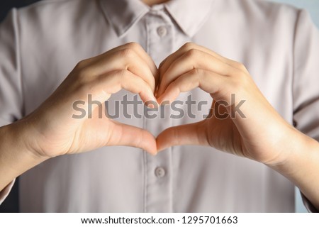 Woman showing heart sign, closeup. Body language