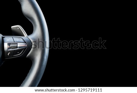 Modern car interior. Steering wheel with media phone control buttons isolated on black background. Car interior details. Car detailing Royalty-Free Stock Photo #1295719111