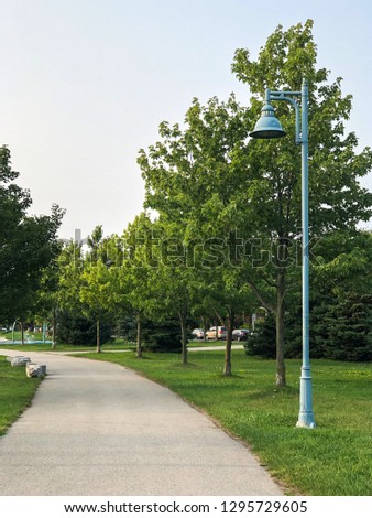 A footpath and lamp post within a neighbourhood park.
