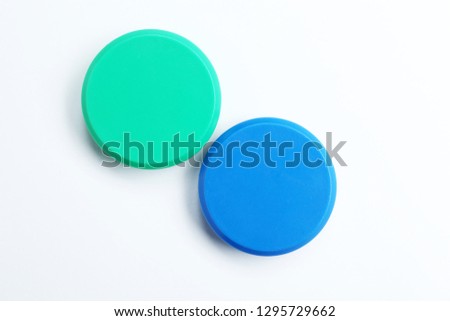 Bright magnets on white background, top view