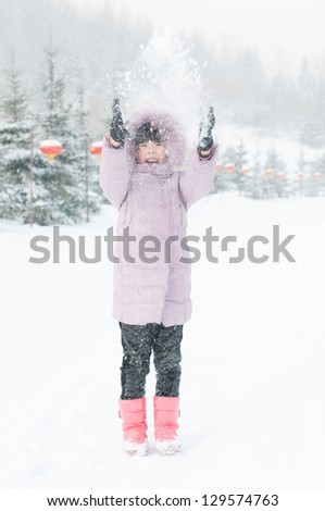 lovely Chinese girl playing snow happily