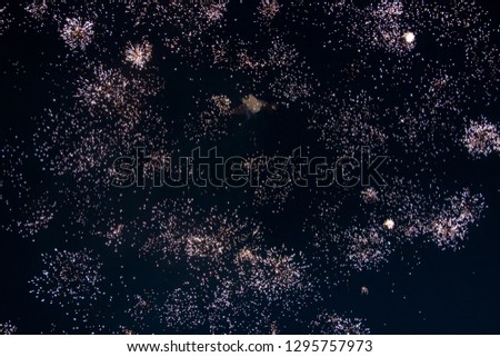 fireworks in the night sky, many small fireworks exploding dark background