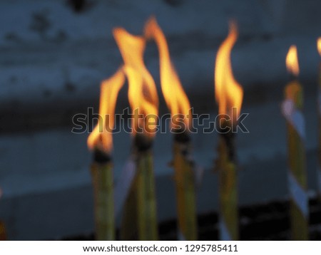 The flame on the candle illuminates the blurred image.