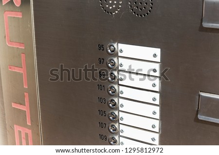 Apartment door bell and numbers without names on the tags.