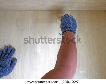 Painter hand of worker use brush for color paint wooden background