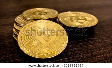 Golden bitcoins on a dark wooden background. Bitcoin is a convenient payment in a global economy market. Virtual digital currency and financial investment trade concept. Blockchain transfers concept.