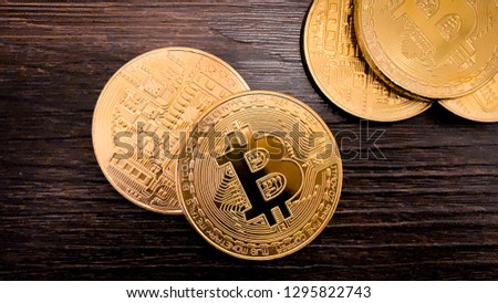 Golden bitcoins on a dark wooden background. Bitcoin is a convenient payment in a global economy market. Virtual digital currency and financial investment trade concept. Blockchain transfers concept.