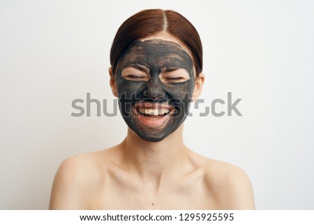 woman laughs in a cosmetic mask made of clay care