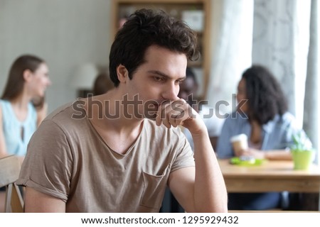 Upset thoughtful man sitting alone, low self-esteem, have no friends, feeling depressed, outsider, Upset mixed race woman offended by friends, feeling unhappy concept, suffering from bullyin Royalty-Free Stock Photo #1295929432