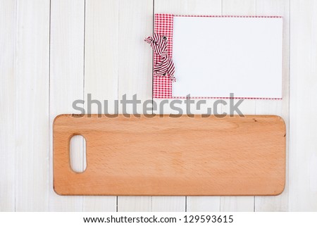Recipe book, kitchen board on white wood background