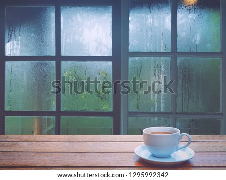 On a rainy day, see the water drops on the outside mirror blurred. (a rainy day window background)
And on the table there is a white coffee cup on the right side.
Feelings, sadness, loneliness
