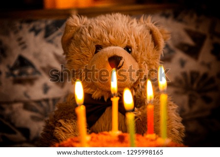 Teddy bear's birthday. Teddy bear with festive cake with candles.