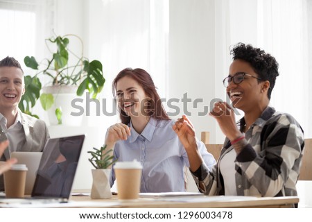 Happy joyful diverse business people laughing at funny joke talking at work break, cheerful corporate team office workers multi-ethnic young coworkers having fun engaged in teambuilding activity Royalty-Free Stock Photo #1296003478