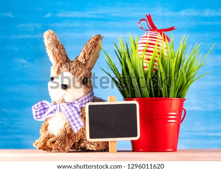 Easter egg and cute bunny on wood table with green grass. Festive decoration