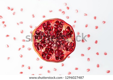 Pomegranate cut open against white background and blurred kernels
