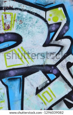 Fragment of graffiti drawings. The old wall decorated with paint stains in the style of street art culture. Colored background texture in cold tones
