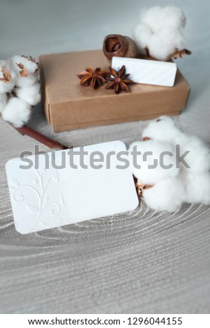 Template for business cards. The layout consists of business cards, boxes, dried flowers, cotton on the table. Blank form on wooden background. Eco style in the design details. 