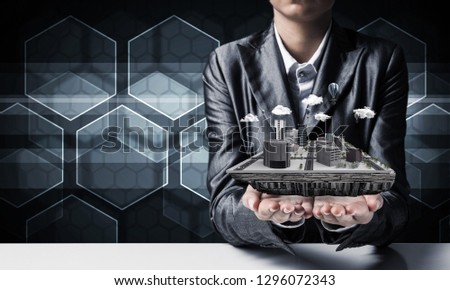 Cropped image of businessman in suit presenting in his hands modern city block with media icons on background. 3D rendering.