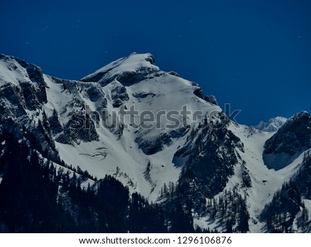 Close-up of snow-capped mountain peak in the mystical moonlight