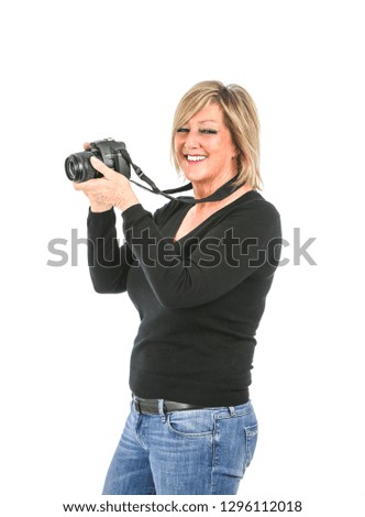 Beautiful middle aged woman smiling while holding a camera against a white background